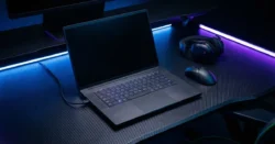 Otevřený herní notebook s RGB podsvícením klávesnice a herním příslušenstvím.