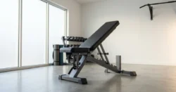 Moderní nastavitelná cvičební lavice v dobře osvětleném domácím fitness koutku.