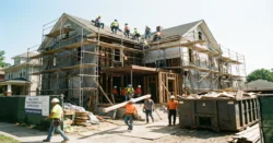 Exteriér rodinného domu v plné rekonstrukci se lešením a stavebním materiálem.